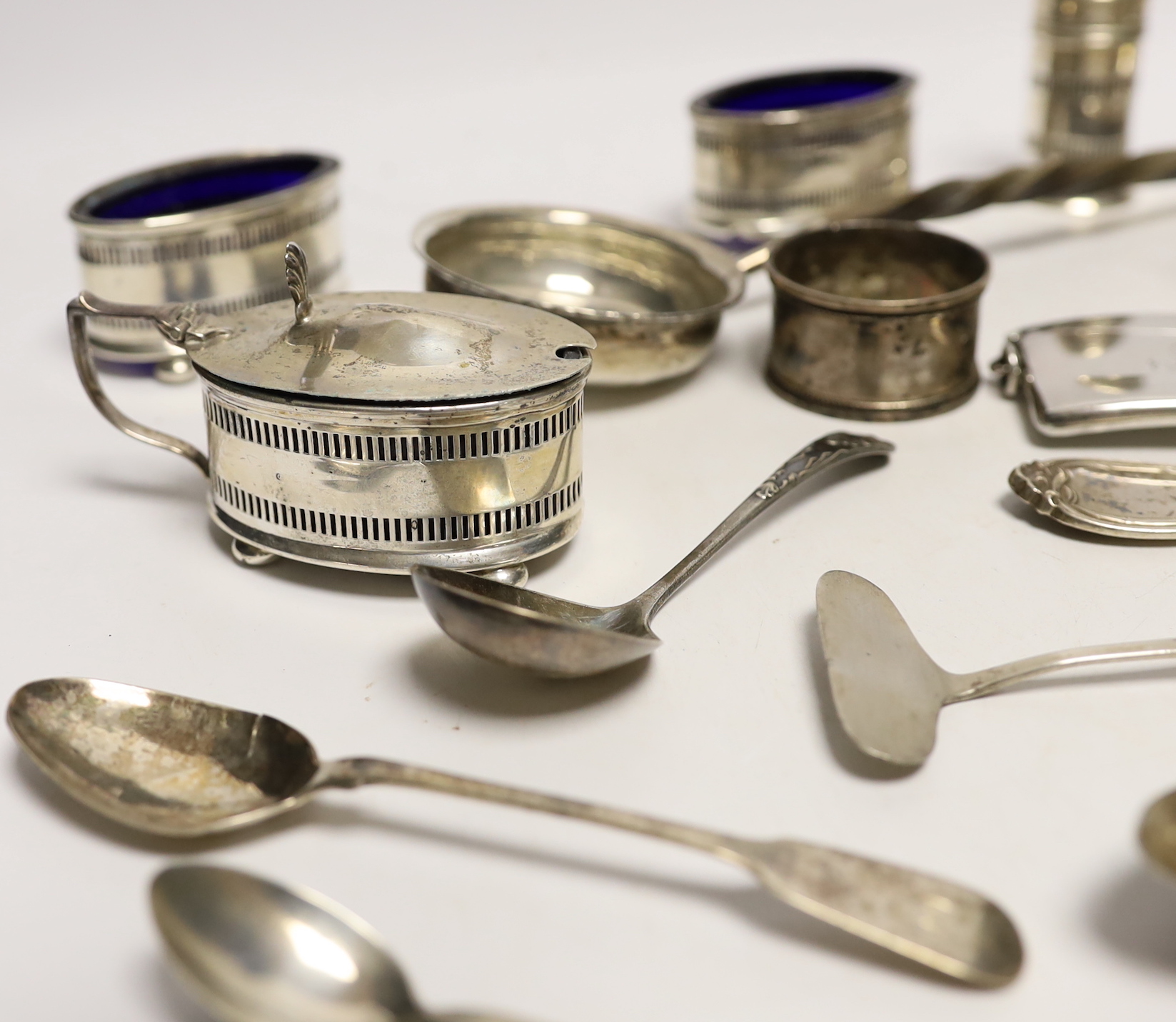 A 1930's silver single handled cup, a four piece silver condiment set, Edwardian silver card case, pair of silver pepperettes, napkin rings, sundry small flatware including sterling etc.